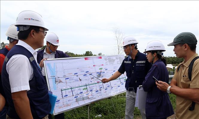 Trong ảnh: Đại diện liên doanh các nhà thầu Kumho – Huyndai và Tư vấn giám sát kỹ thuật kiểm tra bình đồ tại công trường thi công tuyến đường Lộ Tẻ - Rạch Sỏi. Ảnh: Huy Hùng - TTXVN