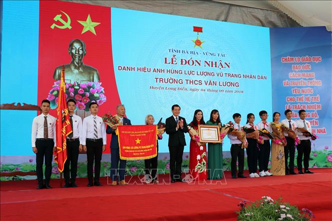 Trong ảnh: Đồng chí Nguyễn Hồng Lĩnh, Bí thư Tỉnh ủy thừa ủy quyền của Chủ tịch nước trao danh hiệu Anh hùng Lực lượng vũ trang cho cựu học sinh và tập thể trường THCS Văn Lương. Ảnh: Đoàn Mạnh Dương - TTXVN
