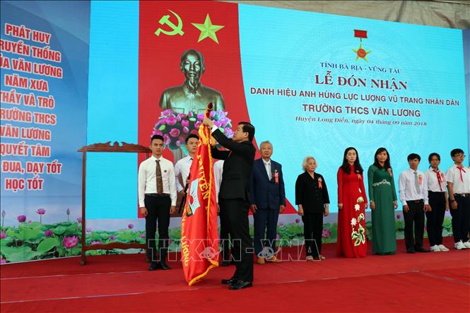 Trong ảnh: Đồng chí Nguyễn Hồng Lĩnh, Bí thư Tỉnh ủy thừa ủy quyền của Chủ tịch nước gắn huy hiệu lên cờ truyền thống của Trường THCS Văn Lương. Ảnh: Đoàn Mạnh Dương - TTXVN
