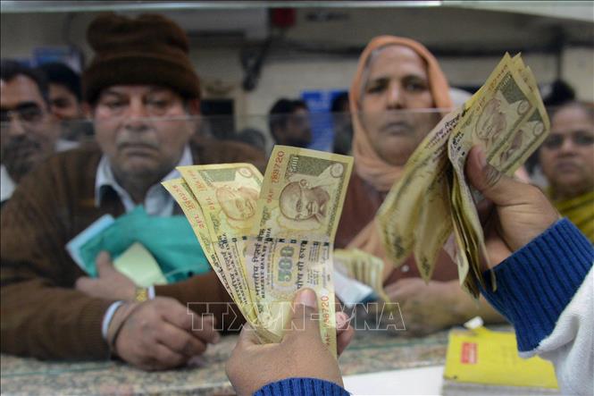 Trong ảnh: Nhân viên kiểm đồng rupee tại một ngân hàng ở Amritsar, Ấn Độ. Ảnh: AFP/TTXVN