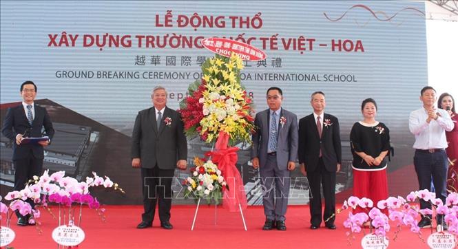 Trong ảnh: Ông Đặng Minh Hưng ( người bên trái), Phó Chủ tịch UBND tỉnh Bình Dương tặng lẵng hoa chúc mừng nhân sự kiện khởi công xây dựng trường quốc tế Việt Hoa. Ảnh: Nguyễn Văn Việt - TTXVN
