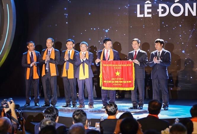 Trong ảnh: Ông Nguyễn Mạnh Hùng (thứ hai từ phải sang), Quyền Bộ trưởng Bộ Thông tin và Truyền thông trao tặng Cờ thi đua của Chính phủ cho Tập đoàn FPT. Ảnh: Trọng Đạt - TTXVN