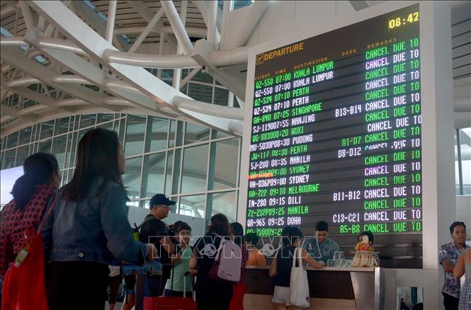 Trong ảnh: Hành khách kiểm tra thông tin chuyến bay tại sân bay Ngurah Rai ở Denpasar, Bali, Indonesia ngày 29/6. Ảnh: AFP/ TTXVN