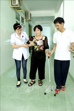Trong ảnh: Nhân viên y tế - bệnh viện Y học cổ truyền Bình Định hỗ trợ người bệnh phục hồi chức năng. Ảnh: Dương Ngọc – TTXVN