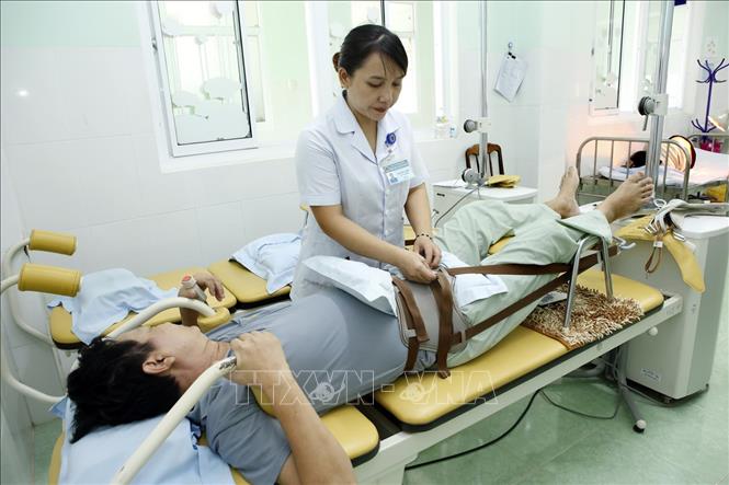 Trong ảnh: Nhân viên y tế luyện tập phục hồi chức năng cho người bệnh tại bệnh viện Y học cổ truyền Bình Định. Ảnh: Dương Ngọc – TTXVN