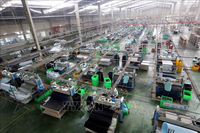 Trong ảnh: Dây chuyền sản xuất giày, dép xuất khẩu tại Công ty TNHH Midori Safety Footwear Việt Nam, vốn đầu tư của Nhật Bản tại khu công nghiệp Điện Nam – Điện Ngọc (Quảng Nam). Ảnh: Danh Lam – TTXVN