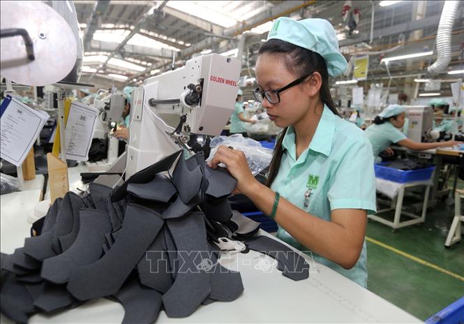 Trong ảnh: Dây chuyền sản xuất giày, dép xuất khẩu tại Công ty TNHH Midori Safety Footwear Việt Nam, vốn đầu tư của Nhật Bản tại khu công nghiệp Điện Nam – Điện Ngọc (Quảng Nam). Ảnh: Danh Lam – TTXVN