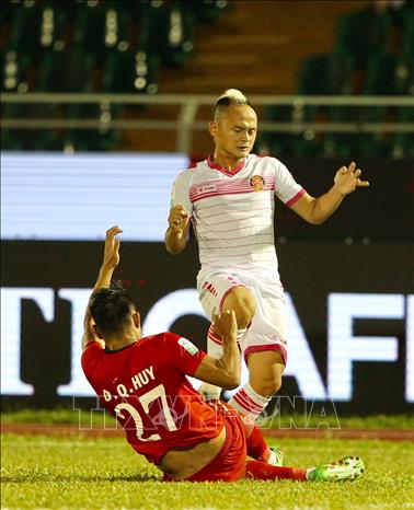 Trong ảnh: Tiền vệ Quốc Phương (91,SGFC) đi bóng trước sự cản phá của Quang Huy (27,TP.HCM). Ảnh: Quang Nhựt - TTXVN
