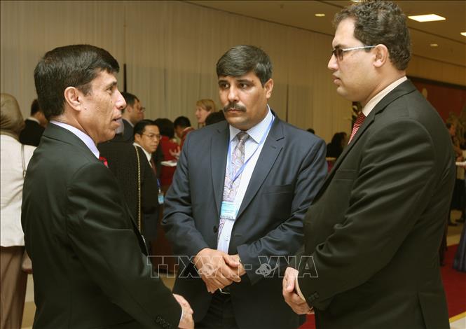 Photo: Delegates discuss on the sidelines of the 7th symposium. VNA Photo