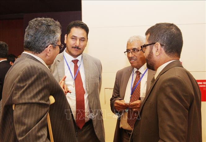 Photo: Delegates discuss on the sidelines of the 7th symposium. VNA Photo