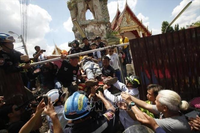 Trong ảnh: Lực lượng cứu hộ chuyển công nhân bị thương ra khỏi đống đổ nát tại hiện trường vụ sập tháp chuông tại ngôi đền Phraya Tham Voraviharn ở Bangkok, Thái Lan ngày 25/9/2018. Ảnh: Bangkok Post/TTXVN