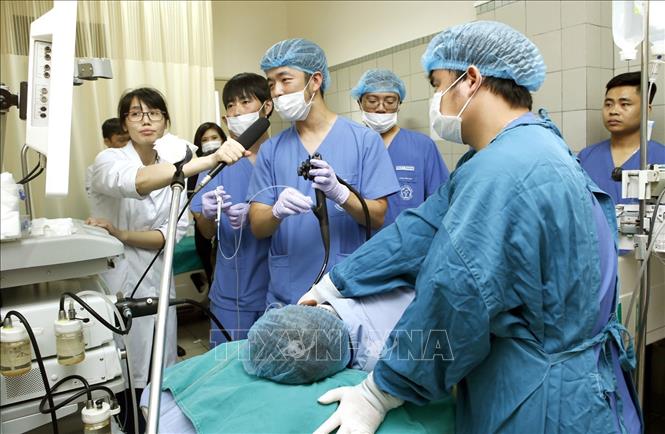 Trong ảnh: Các chuyên gia Nhật Bản chuyển giao kỹ thuật cao, tiến bộ y học cho các giáo sư, bác sĩ Trung tâm Tiêu hóa – Bệnh viện Bạch Mai được truyền hình trực tuyến. Ảnh: Dương Ngọc – TTXVN.
