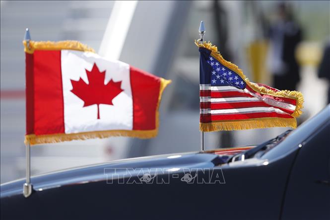 Trong ảnh (tư liệu): Quốc kỳ Mỹ (phải) và Quốc kỳ Canada tại Hội nghị thượng đỉnh Nhóm 7 nước công nghiệp phát triển (G7) ở Quebec, Canada ngày 8/6/2018. Ảnh: AFP/ TTXVN