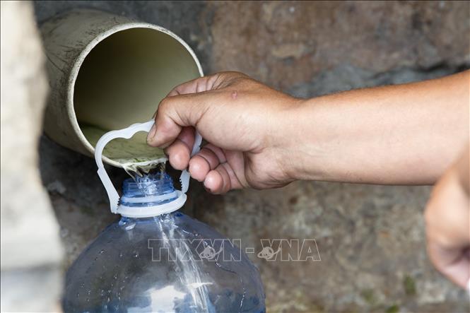 Trong ảnh: Người dân hứng nước từ mạch nước ngầm ở St. James, cách trung tâm thủ đô Cape Town (Nam Phi) 25km, ngày 19/1/2018. Ảnh: AFP/ TTXVN