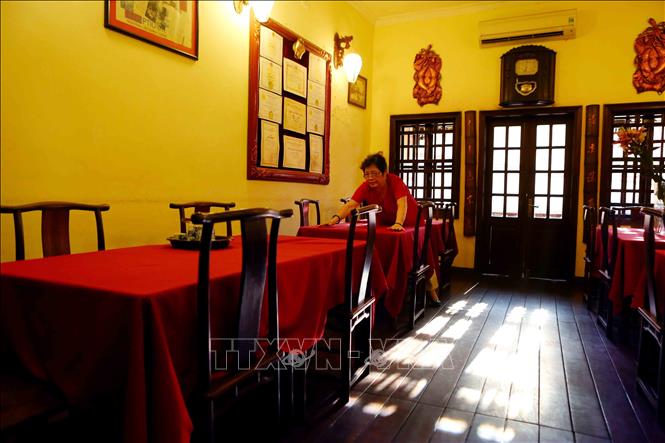 Trong ảnh: Nghệ nhân ẩm thực Phạm Thị Tuyết thường tự tay mình làm những việc nhỏ nhất như dọn dẹp bàn ghế trước giờ mở của nhà hàng. Ảnh: Thành Đạt – TTXVN
