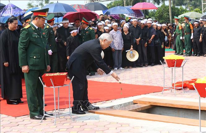 Photo: Party General Secretary Nguyen Phu Trong throw first handfuls of soil over the casket, bidding his last farewell to the Former Party Leader Do Muoi. VNA Photo.