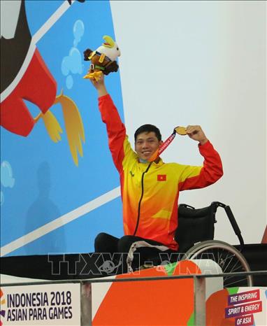 Trong ảnh: VĐV Võ Thanh Tùng với tấm Huy chương vàng thứ 3, nội dung bơi 200m tự do hạng thương tật S5 tại Asian Para Games 2018. Ảnh: Hải Ngọc-TTXVN