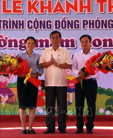 Trong ảnh: Ông Nguyễn Đức Chính, Chủ tịch UBND tỉnh Quảng Trị tặng hoa cho lãnh đạo Tập đoàn Điện lực Việt nam và Quỹ hỗ trợ phòng tránh thiên tai miền Trung tại lễ khánh thành công trình. Trịnh Bang Nhiệm - TTXVN