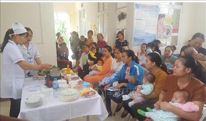 Trong ảnh: Cán bộ Trung tâm y tế xã Cao Ngạn, thành phố Thái Nguyên hướng dẫn các bà mẹ thực hiện bữa ăn dinh dưỡng cho trẻ sơ sinh. Ảnh: Quân Trang - TTXVN