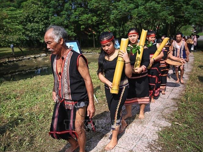 Trong ảnh: Già làng và người dân dẫn đoàn đi lấy nước từ đầu làng để về thực hiện nghi lễ mừng lúa mới. Ảnh: Trọng Đạt - TTXVN