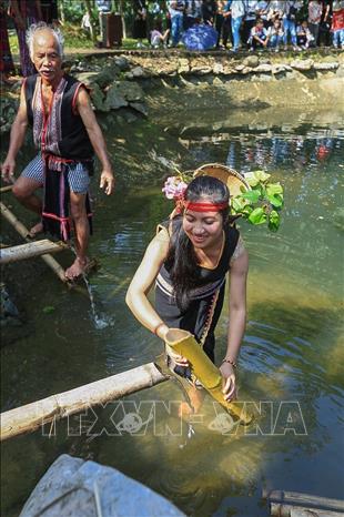 Trong ảnh: Những cô gái Xơ Đăng lấy nước vào ống nứa từ con nước đầu làng. Ảnh: Trọng Đạt - TTXVN