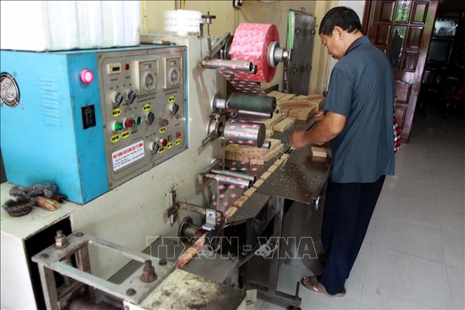 Trong ảnh: Sau khi được cắt thành từng miếng, bánh cáy được đóng gói. Ảnh: Thế Duyệt – TTXVN