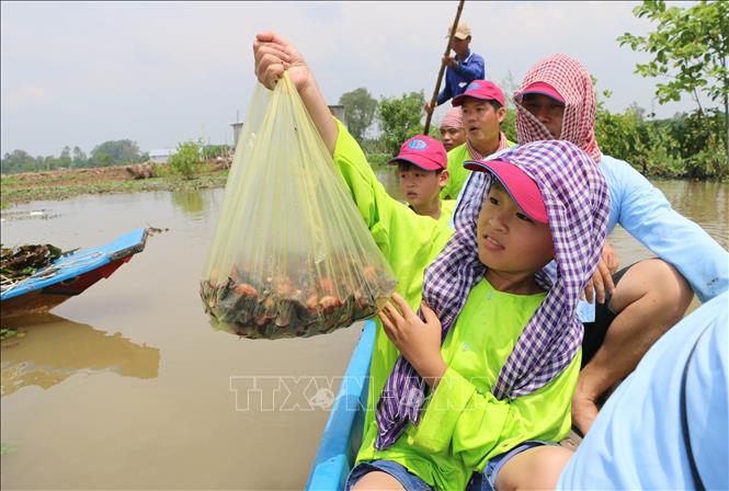 Du khách hào hứng với thành quả gần 2kg ấu sông do chính tay mình hái. Ảnh: Công Mạo-TTXVN