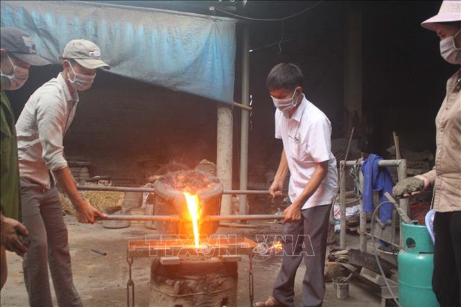 Trong ảnh: Việc rót đồng nóng phải được làm bởi những người thợ có kinh nghiệm 3-5 năm, đây là bước đòi hỏi sự chuẩn xác và nhẹ nhàng. Ảnh: Khiếu Tư - TTXVN