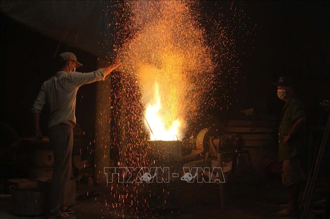 Trong ảnh: Công đoạn nấu đồng. Ảnh: Khiếu Tư - TTXVN
