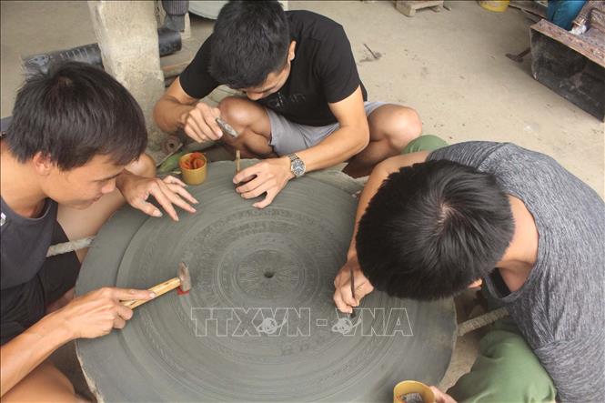 Trong ảnh: Chạm khắc hoa văn trên trống đồng. Ảnh: Khiếu Tư - TTXVN

