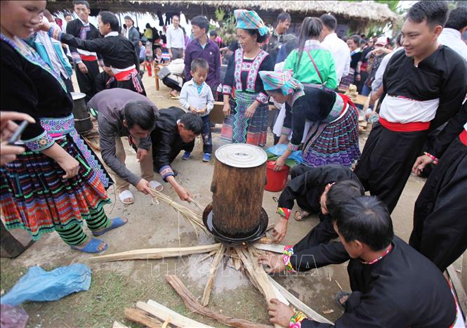 Photo: Participants keep the flame burning to ensure the glutinous rice is evenly cooked. VNA Photo: Quý Trung