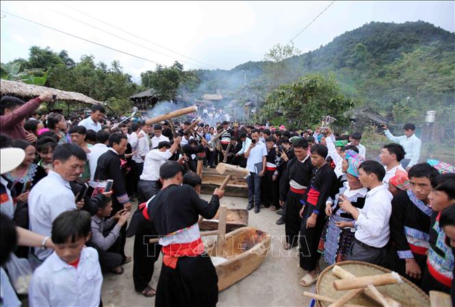 Photo: Two strong men take turns pounding the sticky rice into a paste. When they are tired, two other men will continue in their stead.  VNA Photo: Quý Trung