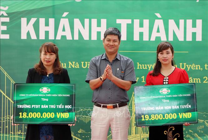 Trong ảnh: Đại diện Công ty Nhựa Thiếu niên Tiền Phong trao hai phần quà cho đại diện Trường PTDT bán trú tiểu học Nậm Sỏ và Trường Mầm non Đán Tuyển của xã Nậm Sỏ tại buổi lễ khánh thành. Ảnh: Quý Trung – TTXVN