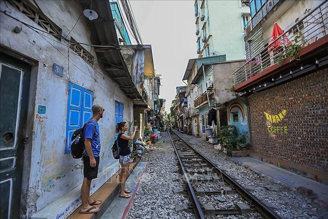 Trọng ảnh: Đoạn đường tàu chạy qua khu dân cư này (đoạn từ phố Điện Biên Phủ qua phố Trần Phú) luôn mang đến một vẻ đẹp vừa cổ kính, vừa dân dã, giản dị gây chút hoài niệm về một Hà Nội xưa cho bất cứ ai ghé qua nơi đây. Ảnh: Trọng Đạt - TTXVN