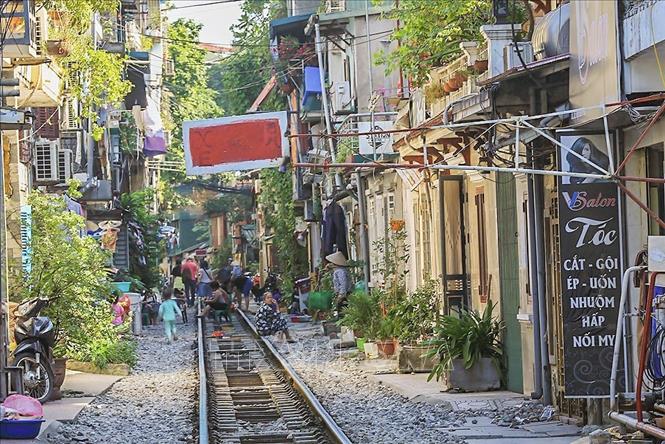 Trọng ảnh: Đoạn đường tàu chạy qua khu dân cư này (đoạn từ phố Điện Biên Phủ qua phố Trần Phú) luôn mang đến một vẻ đẹp vừa cổ kính, vừa dân dã, giản dị gây chút hoài niệm về một Hà Nội xưa cho bất cứ ai ghé qua nơi đây. Ảnh: Trọng Đạt - TTXVN