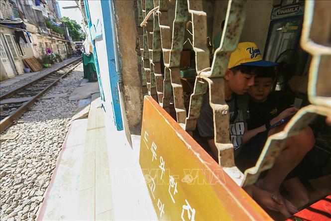 Trong ảnh: Các em nhỏ theo cha mẹ ngồi cafe trong một quán nhỏ ở 