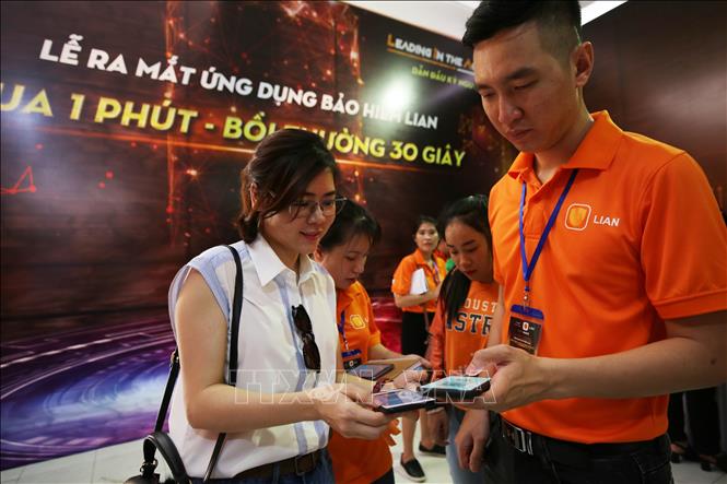 Trong ảnh: Nhân viên tư vấn VASS hướng dẫn cách cài đặt và đăng nhập ứng dụng LIAN tại ngày hội khởi nghiệp. Ảnh: Thế Anh-TTXVN