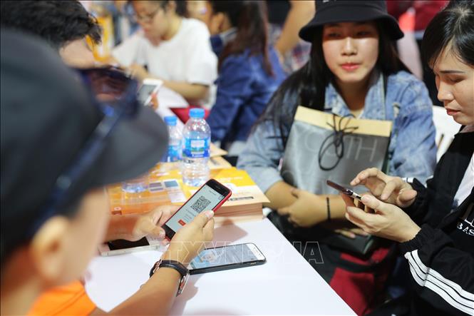 Trong ảnh: Nhân viên tư vấn VASS đang hướng dẫn cách cài đặt và đăng nhập ứng dụng LIAN tại ngày hội khởi nghiệp. Ảnh: Thế Anh-TTXVN