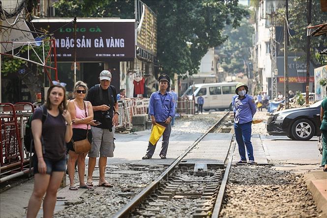 Trong ảnh: Mỗi khi có tàu chạy qua, nhân viên gác chắn luôn túc trực sẵn sàng để nhắc nhở du khách đứng đúng vị trí đảm bảo an toàn. Ảnh: Trọng Đạt - TTXVN