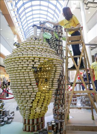 Trong ảnh: Các đội thi xếp mô hình làm từ đồ hộp tại cuộc thi Canstruction ở Vancouver ngày 3/11. Ảnh: THX/TTXVN