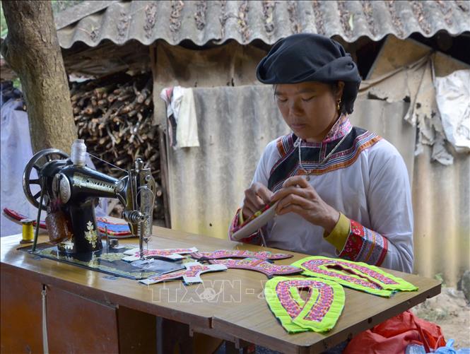 Trong ảnh: Chị Hoàng Lao Tú người dân tộc Xạ Phang đang thêu những đôi giày. Ảnh: Văn Dũng - TTXVN