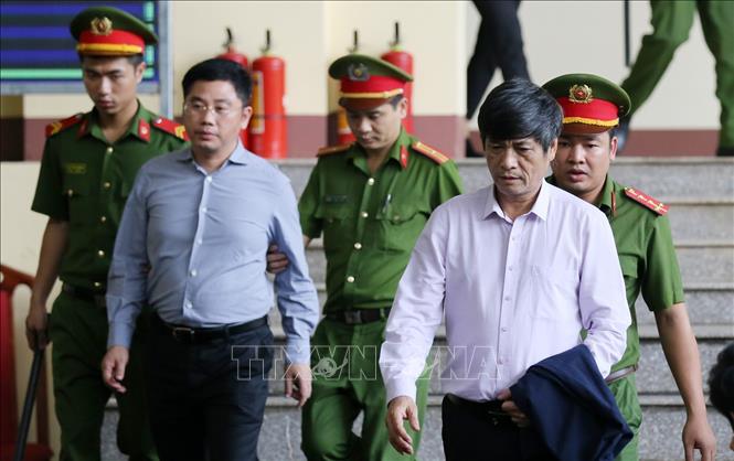 Trong ảnh: Lực lượng chức năng đưa bị cáo Nguyễn Thanh Hóa, cựu Cục trưởng Cục Cảnh sát phòng chống tội phạm sử dụng công nghệ cao C50, Bộ Công an (phải) vào phiên tòa. Ảnh: Trung Kiên – TTXVN.
