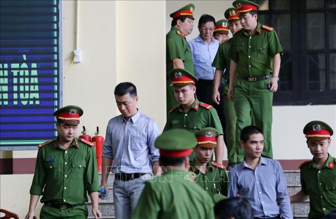 Trong ảnh: Lực lượng chức năng đưa các bị cáo vào phiên tòa. Ảnh: Trung Kiên – TTXVN.