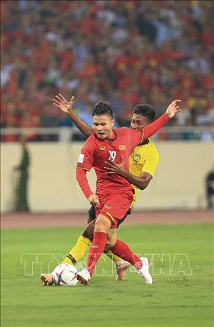 Trong ảnh: Pha nỗ lực đi bóng của tiền vệ Quang Hải trước sự truy cản quyết liệt của cầu thủ Malaysia. Ảnh: Trọng Đạt - TTXVN