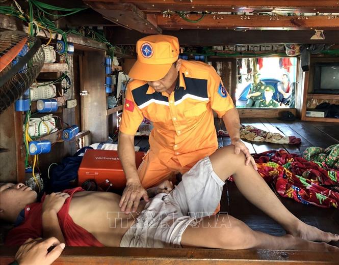 Trong ảnh: Cán bộ Trung tâm Phối hợp tìm kiếm cứu nạn hàng hải Việt Nam sơ cấp cứu cho thuyền viên Tô Minh An (sinh năm 2000) bị đau bụng dữ dội, nôn ói. Ảnh: TTXVN phát