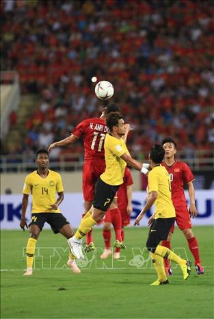 Trong ảnh: Pha tranh chấp bóng bổng của tiền đạo Anh Đức (số 11) với hậu vệ đội Malaysia. Ảnh: Trọng Đạt - TTXVN