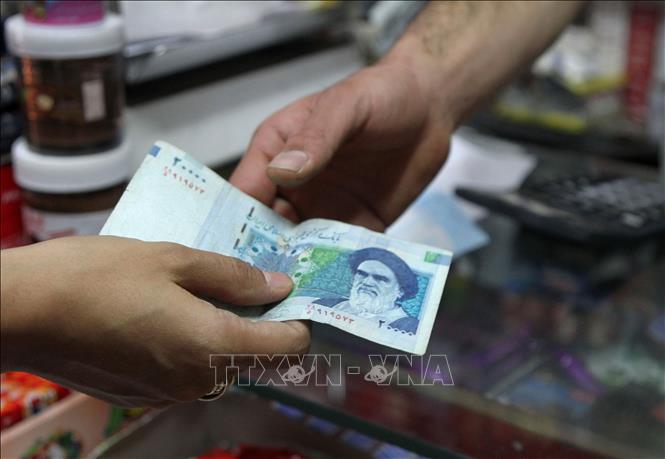 Trong ảnh (tư liệu): Sử dụng đồng rial của Iran để mua bán hàng hóa tại thủ đô Tehran. Ảnh: AFP/ TTXVN