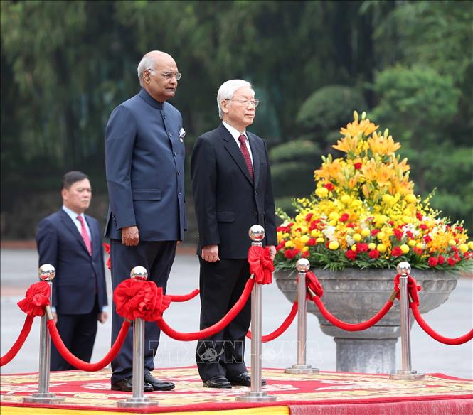 Photo: Party General Secretary, President Nguyen Phu Trong (R) and President of India Ram Nath Kovind (L) stand on the podium of honour and listen to the national anthems of Vietnam and India. VNA Photo: Trí Dũng