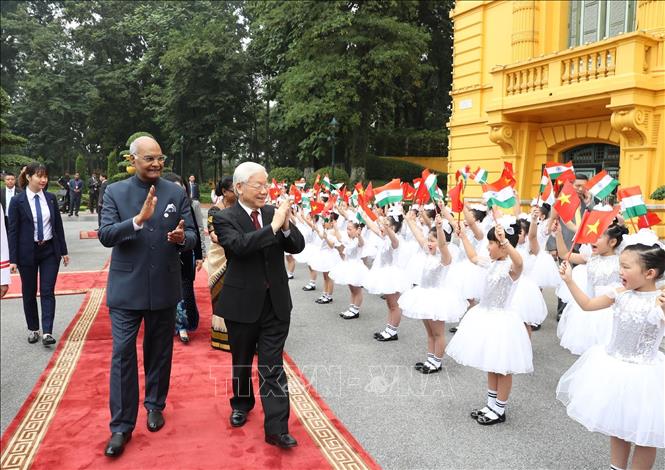 Photo: Children of Hanoi welcome Party General Secretary, President Nguyen Phu Trong (R) and President of India Ram Nath Kovind (L). VNA Photo: Trí Dũng