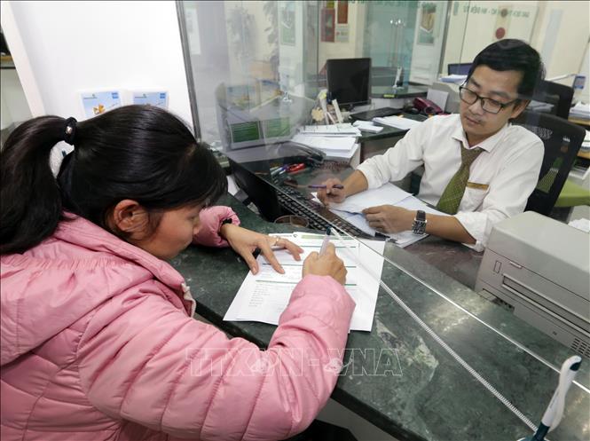 Trong ảnh: Khách hàng giao dịch tại Vietcombank chi nhánh Vĩnh Yên. Ảnh: Trần Việt - TTXVN